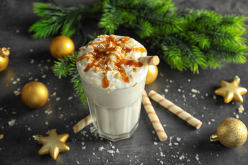 Delicious milkshake with Christmas decoration on grey textured background