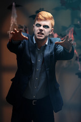 Guy dressed in dead man costume for Halloween, on dark background