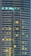Fototapeta na wymiar windows of office buildings illuminated at night for background