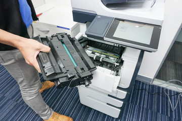 businessman hold ink cartridge to put into printer