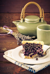 Bilberry, blueberry tart with lavender on white plate, wooden background