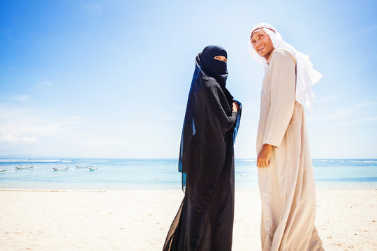 muslim couple on a beach wearing traditional dress