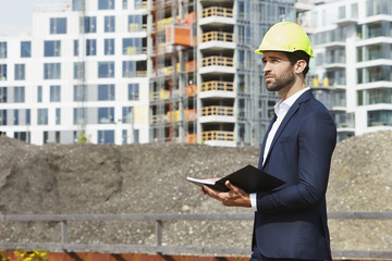 Architect making plan on construction site, looking away