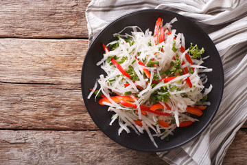 Fresh salad of daikon with pepper and herbs closeup. horizontal top view