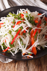 diet food: salad of daikon with pepper and herbs closeup. vertical