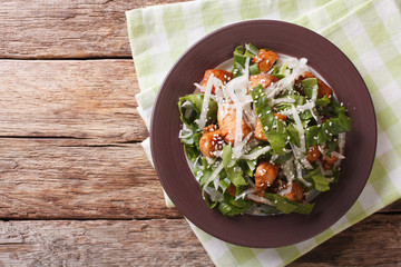 Chicken salad, daikon, spinach and sesame close-up on a plate. horizontal top view
