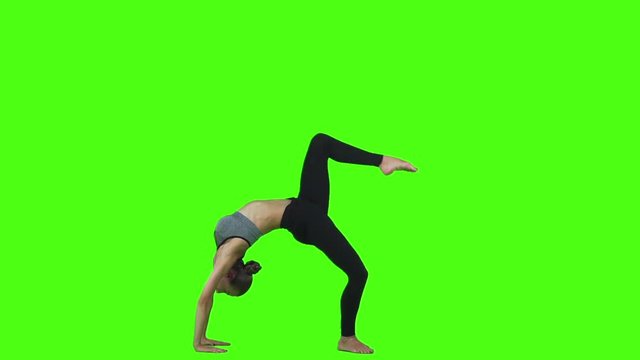 Sporty beautiful young brunette in sportswear doing yoga. Green screen. Slow motion