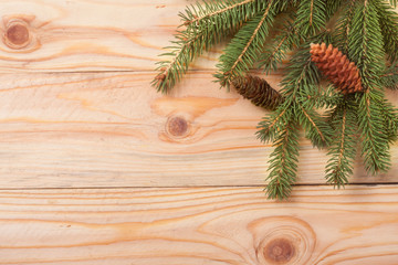 sprigs of fir with cones on a light wooden background for Christmas card