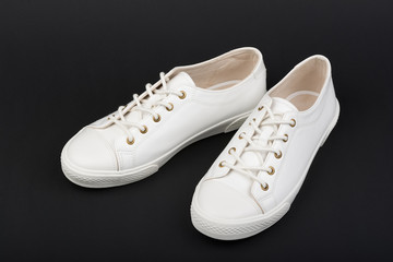 Women's white sport shoes on dark background