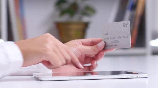 Buying on a virtual shop online with a tablet and a credit card. Close up