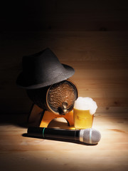 Barrel and glass of beer, microphone on wooden background. concept karaoke