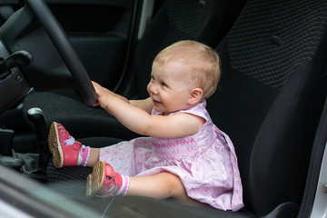 Small cute baby in a car in a warm day