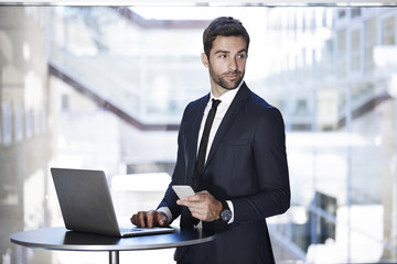 Businessman connected with laptop and smartphone