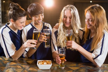 Group of friends toasting glass of beer in party