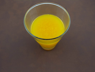 Orange juice. Brown background.