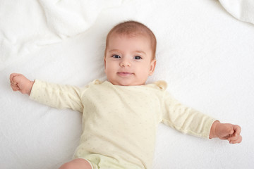 baby portrait lie on white towel in bed