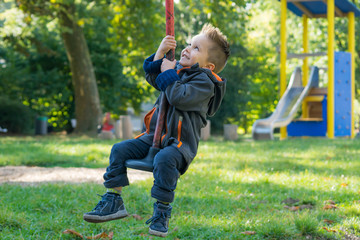 fröhlicher kleiner junge auf dem spielplatz