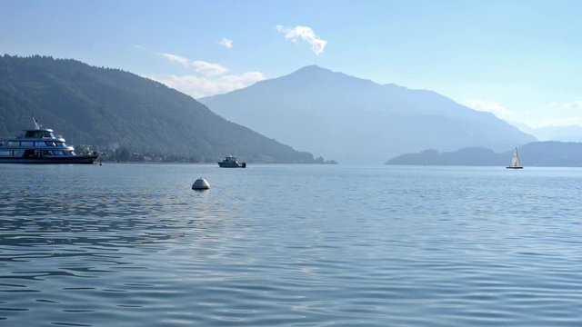 Ferry boat crossing the Lake Zug, in the background the beautiful alp mountain panorama in Switzerland