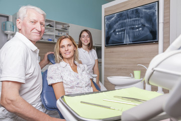 Obraz premium Zahnarzt Team mit Patientin und Röntgenbild im Behandlungszimmer