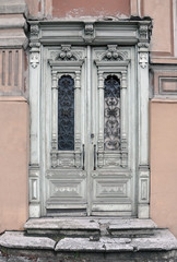 Obraz premium Old vintage door of an historic building with carved wooden decorations painted in white. Vilnius, Lithuania.