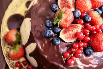 Birthday cake with cream and chocolate, fresh fruit and berries slide.