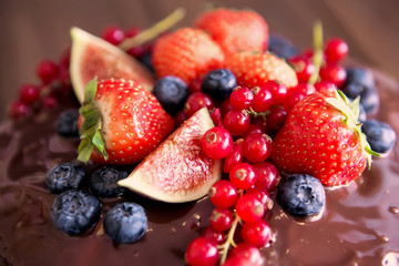 Birthday cake with cream and chocolate, fresh fruit and berries slide.