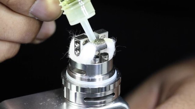 dripping e juice e liquid to new dual kanthal micro coils and organic cotton on atomizer’s deck base of electronic cigarette for vaping, close up scene, high definition, Full HD, 1920x1080