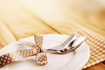 close up dinner setting fork and spoon on plate on wooden 