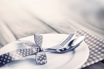 close up dinner setting fork and spoon on plate on wooden 