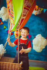 Cheerful smile of the boy in the studio with the balloon