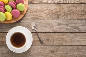 Fototapeta na wymiar Macarons with cup of tea and spoon 