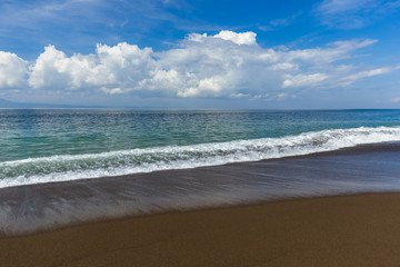 Fototapeta na wymiar Black volcanic sand beach in Bali Island Indonesia