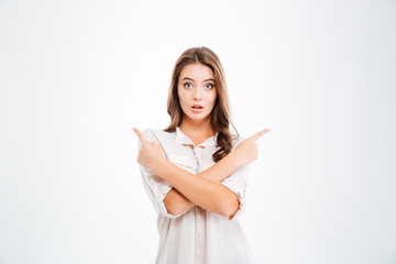 Fototapeta premium Pretty young woman standing and pointing two fingers away