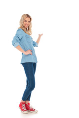 full body picture of a smiling young casual woman presenting