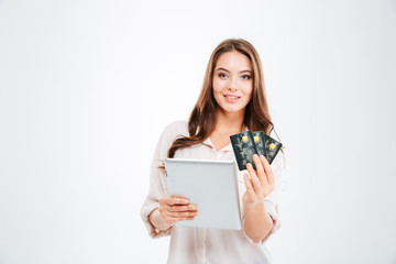 Fototapeta premium Smiling young woman holding bank card and tablet computer