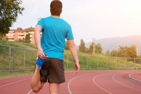 Runner Making Stretching On The Track