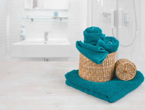 Turquoise spa towels and wicker baskets on defocused bathroom interior