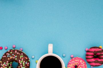 Sweet donuts with coffee on the blue background.