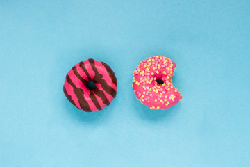 Two pink donuts on the blue table