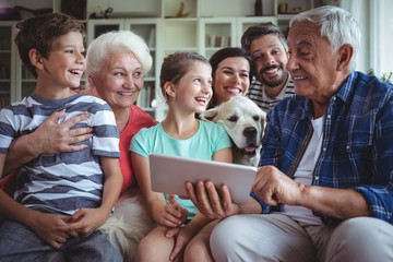 Happy multi-generation family using digital tablet  - Powered by Adobe