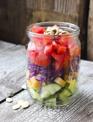 Healthy homemade mason jar salad with cucumber, cheese, tomato,
