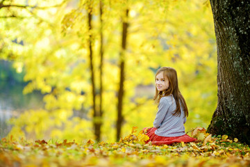 Cute little girl having fun on beautiful autumn day