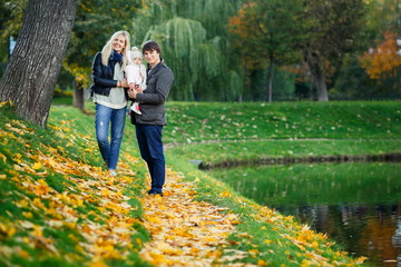 Obraz premium Portrait of happy family with daughter in autumn park