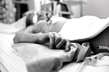 Hand extremely exhausted patients dying in a hospital bed. Black - obrazy, fototapety, plakaty
