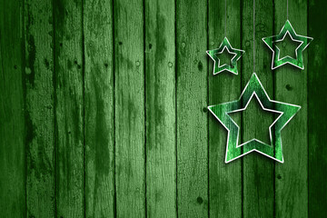 Naklejka premium Abstract green wooden background with illustrated glass effect Christmas and New Year Holiday decoration star shapes hanging on string. Xmas decoration with copy space background.