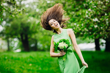 Naklejka na ściany i meble beautiful young woman standing in a green garden