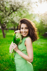 beautiful woman holding a bunch of flowers with lily of the vall