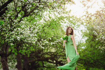 beautiful young woman standing in a green garden