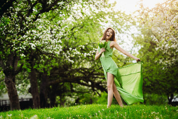 beautiful young woman standing in a green garden