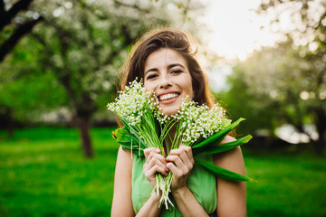woman holding a bunch of flowers with lily of the valley